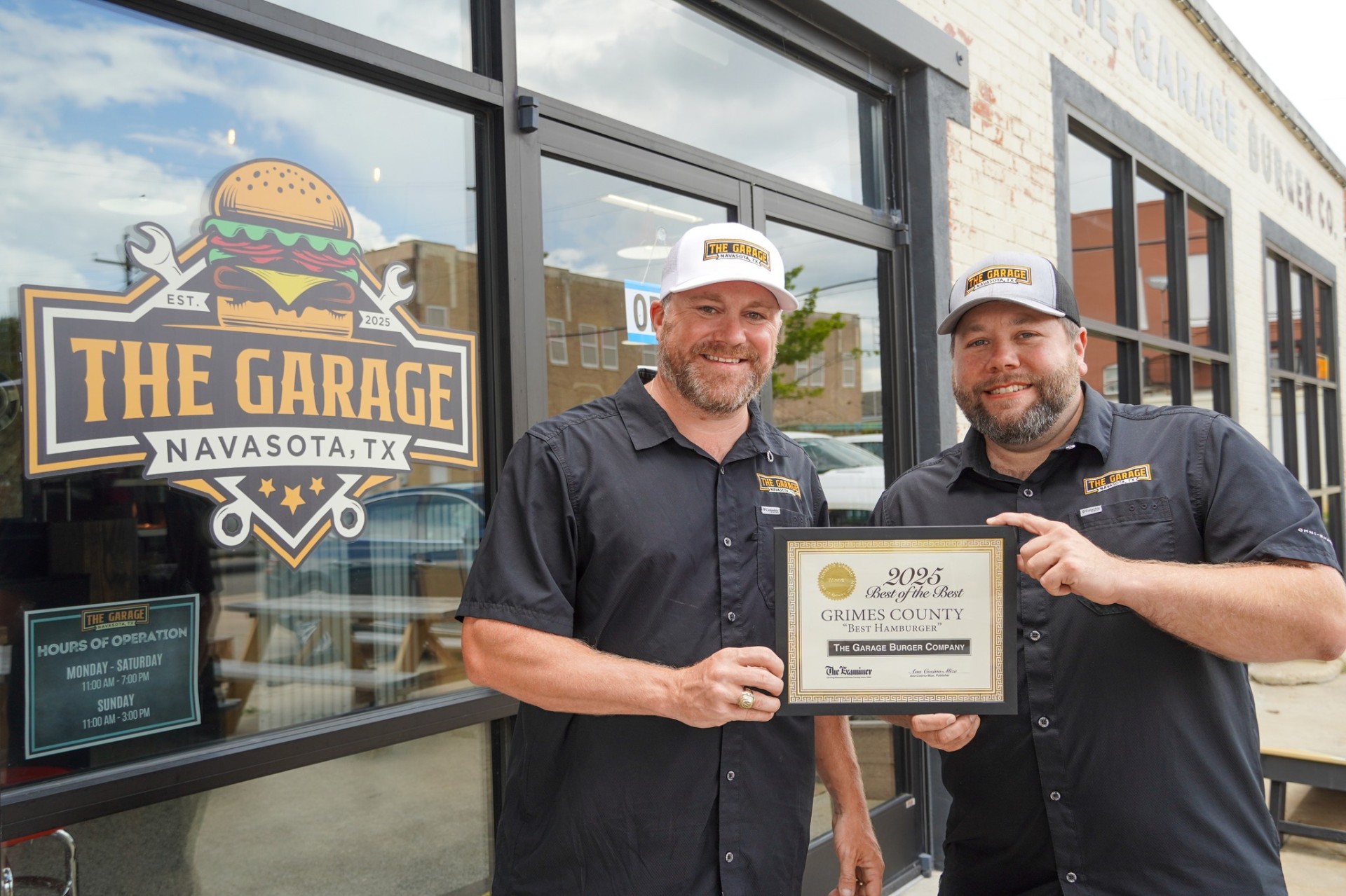 The Garage Burger Company owners holding their 2025 Best Hamburger in Grimes County award